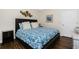 Comfortable bedroom with wood floors, white trim, and a decorative metal wall sculpture at 3207 Village Ln, Port Charlotte, FL 33953