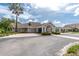 A clubhouse with manicured landscaping, beige exterior, and a welcoming entryway in a sunny scene at 3207 Village Ln, Port Charlotte, FL 33953