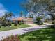 Charming home featuring a well-kept lawn and landscaping, as well as a brick paver driveway at 3207 Village Ln, Port Charlotte, FL 33953