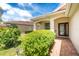 Inviting front entrance featuring a tiled roof, well-manicured landscaping, and a beautiful, decorative glass front door at 3207 Village Ln, Port Charlotte, FL 33953