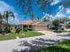 Charming single-story home with a well-maintained front yard, lush landscaping, and paved driveway at 3207 Village Ln, Port Charlotte, FL 33953