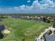 Scenic aerial view of a meticulously manicured golf course with blue skies and scattered clouds at 3207 Village Ln, Port Charlotte, FL 33953