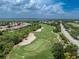 Aerial view of a lush green golf course next to a neighborhood and waterway on a sunny day at 3207 Village Ln, Port Charlotte, FL 33953
