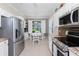 Bright kitchen with stainless appliances, a breakfast nook, and stylish light fixture at 3207 Village Ln, Port Charlotte, FL 33953