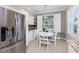 Kitchen nook with stainless refrigerator, white cabinets, stylish decor and shutters overlooking the outside at 3207 Village Ln, Port Charlotte, FL 33953
