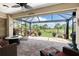 Relaxing screened lanai with lovely stone flooring, a fire pit and golf course views at 3207 Village Ln, Port Charlotte, FL 33953