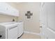 A laundry room featuring a white washer and dryer, white cabinets, and a decorated wall at 3207 Village Ln, Port Charlotte, FL 33953