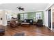 Spacious living room with hardwood floors, fan, neutral paint, and sliding glass doors to the patio at 3207 Village Ln, Port Charlotte, FL 33953