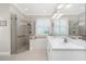 Elegant bathroom featuring a glass shower, soaking tub, and double vanity with marble countertops at 3207 Village Ln, Port Charlotte, FL 33953