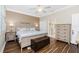 Comfortable main bedroom with wood floors, a ceiling fan, dresser, and ensuite bathroom at 3207 Village Ln, Port Charlotte, FL 33953