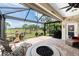 A covered patio with views of a golf course, a fire pit, a seating area, and an outdoor grill at 3207 Village Ln, Port Charlotte, FL 33953