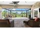 A screened-in patio with comfortable seating and golf course views at 3207 Village Ln, Port Charlotte, FL 33953