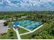 Aerial view of well maintained community pickleball courts surrounded by green space and trees at 3207 Village Ln, Port Charlotte, FL 33953