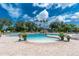 An inviting community pool area surrounded by lush landscaping and comfortable lounge chairs at 3207 Village Ln, Port Charlotte, FL 33953