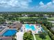Aerial view of a community pool, surrounded by lounge chairs, umbrellas, and palm trees at 3207 Village Ln, Port Charlotte, FL 33953