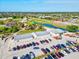 Aerial view of the golf course and clubhouse with parking lot and cars at 34 Broadmoor Ln, Rotonda West, FL 33947