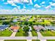 Aerial view of a residential neighborhood with canals, lush greenery, and blue skies with fluffy clouds at 34 Broadmoor Ln, Rotonda West, FL 33947