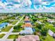 Wide aerial shot of a neighborhood featuring canals and well-maintained lawns with houses and trees at 34 Broadmoor Ln, Rotonda West, FL 33947