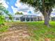 A spacious backyard boasts a covered, screened-in lanai and pool, with mature trees and a fenced perimeter at 34 Broadmoor Ln, Rotonda West, FL 33947