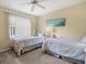 Bright bedroom with two twin beds, a window, and a ceiling fan at 34 Broadmoor Ln, Rotonda West, FL 33947