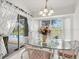 An sun-filled dining room with a glass table, white wicker chairs, slider doors leading to a pool and outdoor patio at 34 Broadmoor Ln, Rotonda West, FL 33947