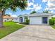 Inviting home featuring manicured landscaping, a screened entry, and a large two-car garage at 34 Broadmoor Ln, Rotonda West, FL 33947