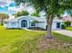 Charming single-story home showcasing manicured landscaping and a well-maintained lawn at 34 Broadmoor Ln, Rotonda West, FL 33947