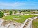 Aerial shot of a golf course with manicured greens, sand traps, and winding paths for golf carts at 34 Broadmoor Ln, Rotonda West, FL 33947