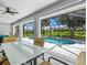 The covered lanai features a dining area, ceiling fan, and views of the screened pool and green lawn at 34 Broadmoor Ln, Rotonda West, FL 33947