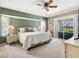 Bright bedroom with a sliding glass door to the porch, bay windows, carpet flooring, and a king-sized bed at 34 Broadmoor Ln, Rotonda West, FL 33947