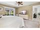 Well-lit bedroom with a large window view, TV, carpeted floor, and an open entrance to the rest of the house at 34 Broadmoor Ln, Rotonda West, FL 33947