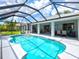 A scenic view of the home's screened-in pool and covered lanai set against a bright, blue sky at 34 Broadmoor Ln, Rotonda West, FL 33947