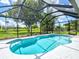Screened-in pool surrounded by lush landscaping, creating a private and serene outdoor oasis at 34 Broadmoor Ln, Rotonda West, FL 33947