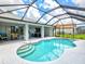 An elevated view of the screened-in pool and covered lanai with outdoor seating and dining areas at 34 Broadmoor Ln, Rotonda West, FL 33947