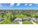 Aerial view showcases a home with mature trees and landscaping within the neighborhood at 55 Mark Twain Ln, Rotonda West, FL 33947