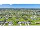 Expansive aerial view of a neighborhood showcasing lush landscaping, lakes, and blue skies at 55 Mark Twain Ln, Rotonda West, FL 33947