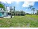 Expansive backyard with lush green grass, mature trees, and an outdoor seating area at 55 Mark Twain Ln, Rotonda West, FL 33947