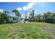 Wide view of the back yard with mature landscaping and an outdoor seating area at 55 Mark Twain Ln, Rotonda West, FL 33947