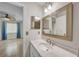 Bright bathroom with a tiled shower, large mirror, and view of bedroom with wood-look flooring at 55 Mark Twain Ln, Rotonda West, FL 33947