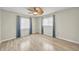 Bedroom with wood-look floors, ceiling fan, and two windows with white blinds allowing for plenty of natural light at 55 Mark Twain Ln, Rotonda West, FL 33947