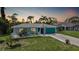 Charming single-story home with a well-manicured lawn, tropical landscaping and turquoise accents at 55 Mark Twain Ln, Rotonda West, FL 33947