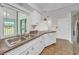 Efficient kitchen design with stainless steel appliances, white cabinetry and tile floors at 55 Mark Twain Ln, Rotonda West, FL 33947