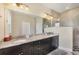Bathroom with double vanity, granite countertop, and updated lighting at 576 Box Elder Ct, Englewood, FL 34223