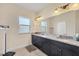 Bathroom with double vanity, granite countertop, and updated lighting at 576 Box Elder Ct, Englewood, FL 34223