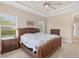 Bedroom featuring a decorative tray ceiling and wicker furniture at 576 Box Elder Ct, Englewood, FL 34223
