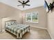 Comfortable bedroom with a ceiling fan, tiled floors, and a large window for natural light at 576 Box Elder Ct, Englewood, FL 34223