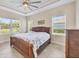 Bedroom with a decorative tray ceiling, wicker furnishings and a large window overlooking the backyard at 576 Box Elder Ct, Englewood, FL 34223