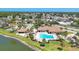 Aerial view showcases the community pool, cabana, lounge area, and adjacent lake at 576 Box Elder Ct, Englewood, FL 34223