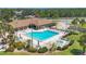 Aerial view of the community pool area with a hot tub, lounge chairs, and well-maintained landscaping at 576 Box Elder Ct, Englewood, FL 34223