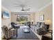 Bright living room featuring tile floors, ceiling fan and a sliding glass door to the backyard at 576 Box Elder Ct, Englewood, FL 34223